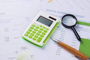 work with a magnifying glass, a calculator and papers photo