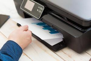 Man's hand making copies. Working with printer photo