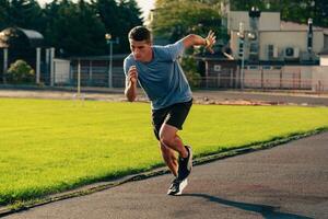 Men engages in sprinting on a track in a sports facility in bright daylight while focusing on speed and technique photo