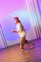Contemporary dancer performs in stylish studio with colorful lighting and geometric projection at evening event photo