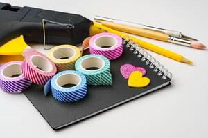 Crafting supplies neatly arranged with colorful tapes and tools on a workspace photo