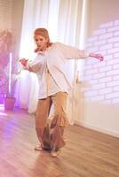 Person dancing in a stylish indoor space with bright lighting and a relaxed atmosphere during a creative event photo