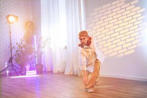 Dancer performing a contemporary routine in a bright studio with creative lighting and serene atmosphere photo