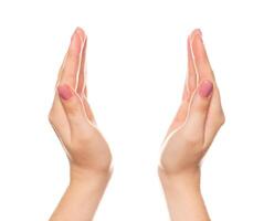 Hands positioned symmetrically against a plain background showing a delicate gesture of greeting or blessing photo