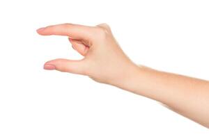 Hand gesture shows a small object being held with fingers in bright light setting photo