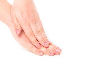 Elegant hands with manicured nails resting gently on each other in a soft, light atmosphere photo