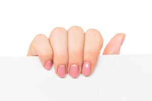Hand with perfectly manicured nails holding a blank sheet of paper against a white background photo
