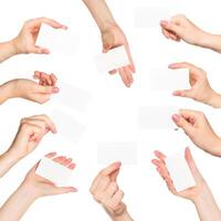 Many hands hold blank business cards in a collaborative workspace during a networking event photo