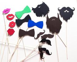 Fun photo booth props featuring colorful mustaches, lips, and bow ties for a party setting