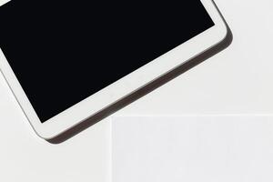 Tablet rests on a flat surface with a blank screen, showcasing its design and sleek appearance in a minimalistic setting photo