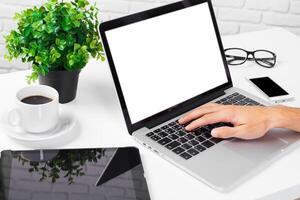 Working at a modern desk with laptop, coffee, and tablet in a bright environment photo