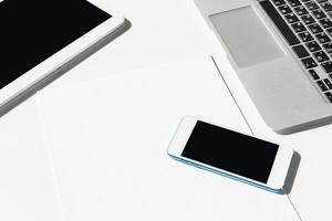 Technology devices are arranged on a clean workspace during a productive work session in an office photo