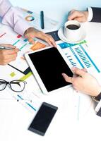 Team collaborates on business strategies with digital devices and documents at a modern workspace photo