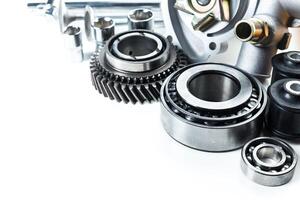 Collection of automotive parts displayed on a clean surface showcasing gears, bearings, and various mechanical components photo