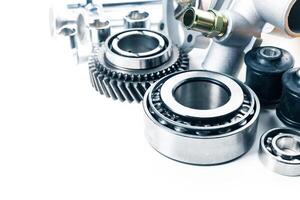 Close-up of various mechanical components including gears, bearings, and fasteners on a workbench in a workshop setting photo