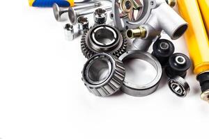 Collection of automotive parts displayed on a clean surface showcasing gears, bearings, and various mechanical components photo
