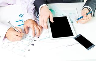 Collaboration among professionals using digital devices and documents at a modern workspace photo