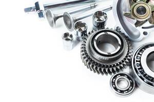 Various metallic components and tools arranged on a white surface for automotive or mechanical use photo
