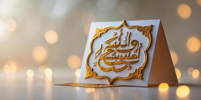 Elegant gold calligraphy card displayed on a reflective surface with soft bokeh lights in the background photo