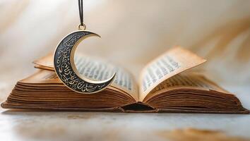 Open book with intricate crescent moon pendant hanging above on a blurred background in soft light photo