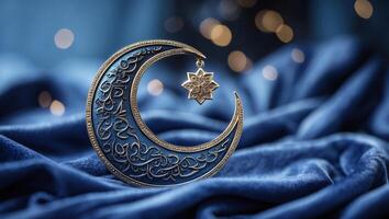 Intricate crescent moon decoration with ornate patterns and star pendant on soft blue fabric illuminated by warm bokeh lights photo