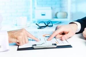 Discussion of financial report with charts at a business meeting in a modern office setting photo