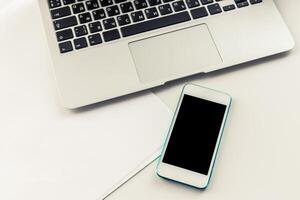 Workspace with laptop and smartphone on a clean desk showing organization and productivity in daily activities photo