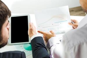 Business professionals analyze data reports and graphs during a strategic meeting in a modern office environment photo