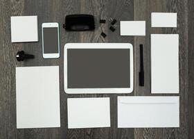 Office workspace layout with digital devices and stationery materials in a minimalistic arrangement photo