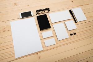 Collection of stationery items arranged on a wooden surface in a minimalist workspace setting photo