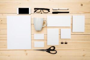 Workspace setup with stationery and digital devices arranged on wooden tabletop photo