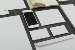 Collection of blank stationery arranged neatly on a wooden table for creative projects in a modern workspace photo