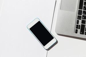 Mobile device and laptop placed on a clean desk showcasing a minimalistic workspace ideal for productivity and focus photo