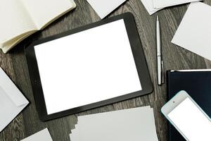 Digital workspace with tablet, pen, and blank papers on wooden desk during a creative brainstorming session photo