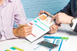 Business professionals discussing financial reports at a meeting table using charts and graphs to analyze performance data photo