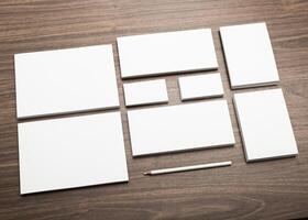 Arrangement of various blank stationery items on a wooden table for creative projects or office use photo
