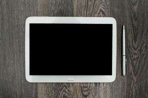 Blank tablet and pen on wooden surface ready for creative work and note-taking during a productive session photo