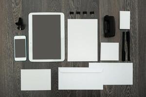 Organized workspace layout featuring digital and stationary tools on wooden background photo