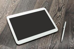 Tablet and pen on wooden table during work session in a modern office setting photo