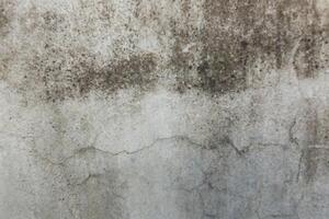 Surface with visible stains and cracks showing wear over time in an indoor environment photo