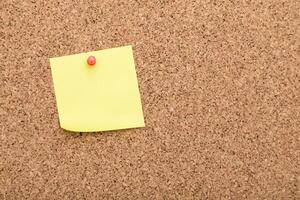 Sticky note pinned on a corkboard in an office setting during daytime photo