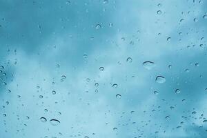 Raindrops collect on a window as gray clouds loom overhead during a rainy afternoon photo