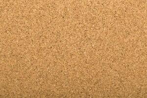 Corkboard surface with a natural texture displaying a warm and neutral color palette in a workspace setting photo