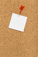 Blank note pinned to a corkboard suggesting a reminder or upcoming event on a simple workspace photo