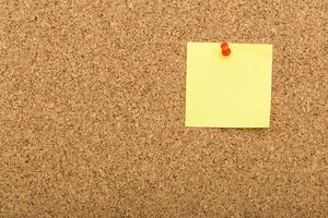 Note pinned to a corkboard highlighting organization and reminders in a workspace setting photo