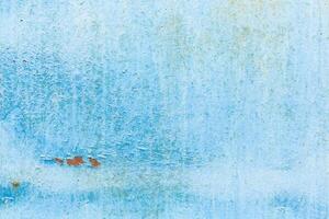 Textured light blue wall with subtle variations and a hint of rust spots in an urban environment during daylight photo