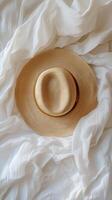 A hat is laying on top of a white sheet photo