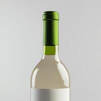 A bottle of white wine with a green cap photo