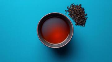 Black tea with a cup on a blue background photo