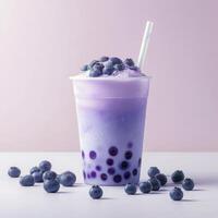 A purple drink with blueberries and a straw photo
